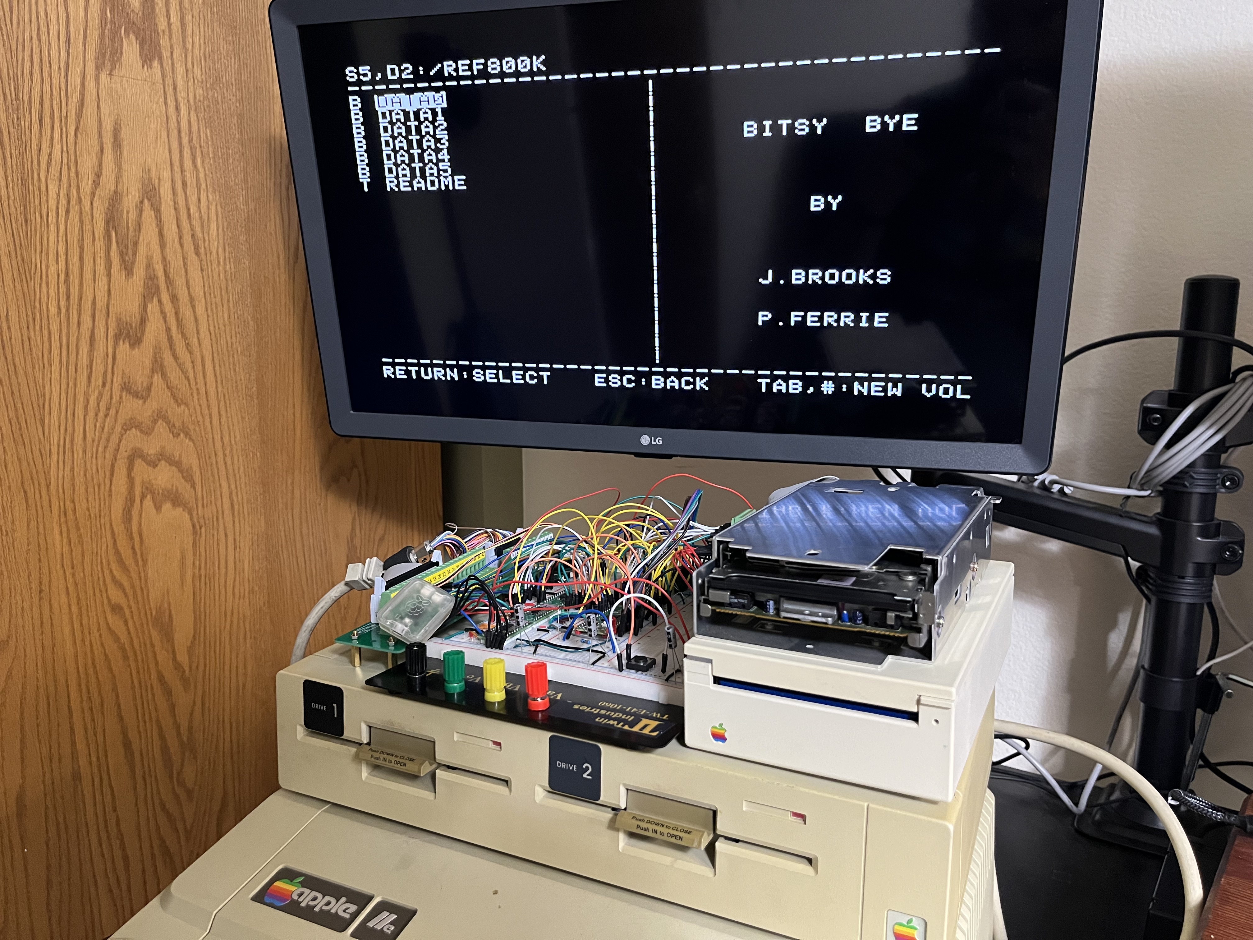 The whole rig running off the IIe: my board on the breadboard, the Sony mechanism sitting on the working UniDisk, both chained on the Liron card. Bitsy Bye is listing slot 5 drive 2.