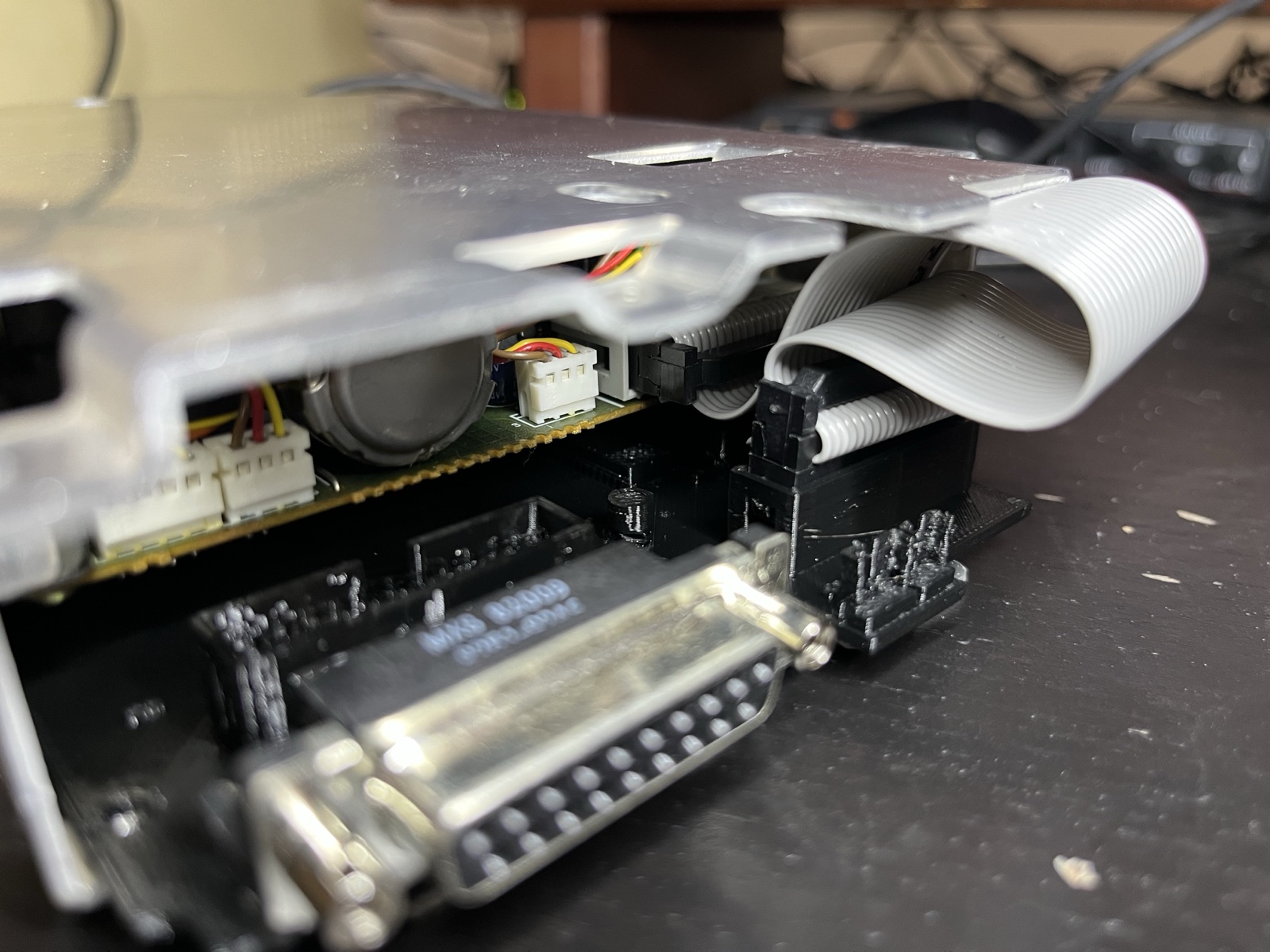 The print in the UniDisk under the mechanism: ribbon on the mechanism header, the LED and eject leads on their tab headers, the DB-19 at the rear.