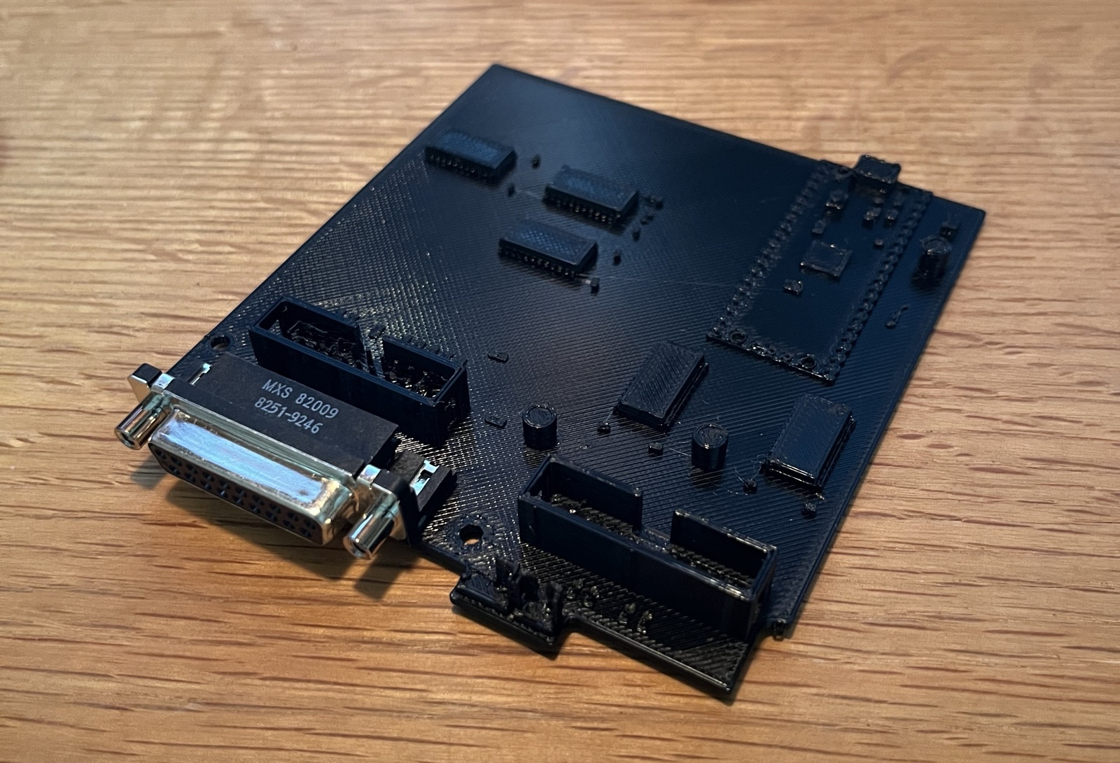 The flat print of the second layout with the real DB-19 dropped into its printed holes. Pins trimmed, board thickened so nothing floats, USB jack filled. Printed flat, no supports.